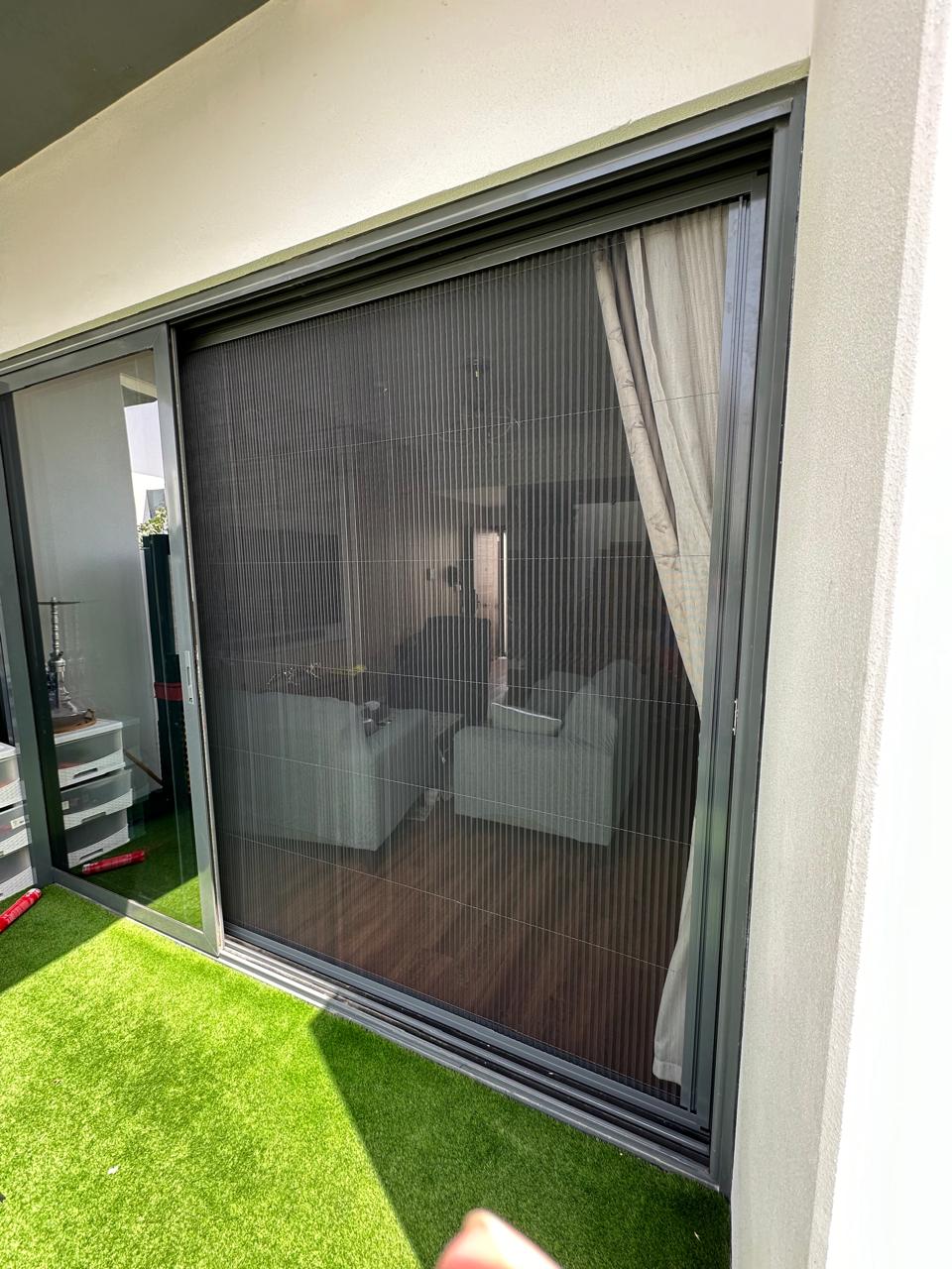 Motorized fly screen dropped down the side of a villa pergola in Dubai