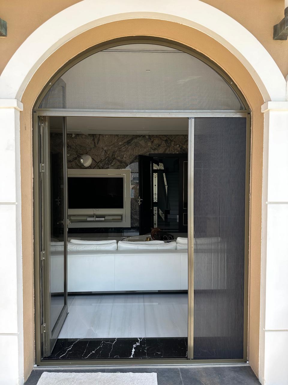 Fly screen fitted on a villa patio door opening onto a garden in Mirdif, Dubai